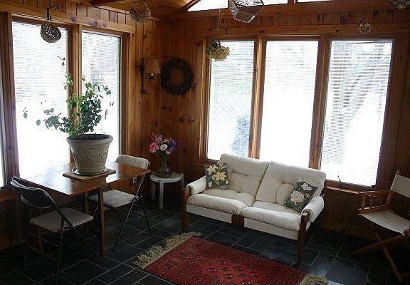 Three Season Sunroom with Pella windows and slate floor leads to large deck