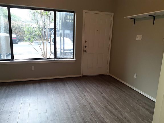 LIVING ROOM VIEW OF FRONT DOOR & SHELVING ON WALL