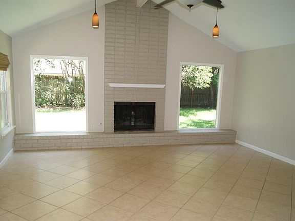 Huge, 20' x 18' Family Room boasts a high, vaulted ceiling, tiled floor, fireplace and lots of natural light.