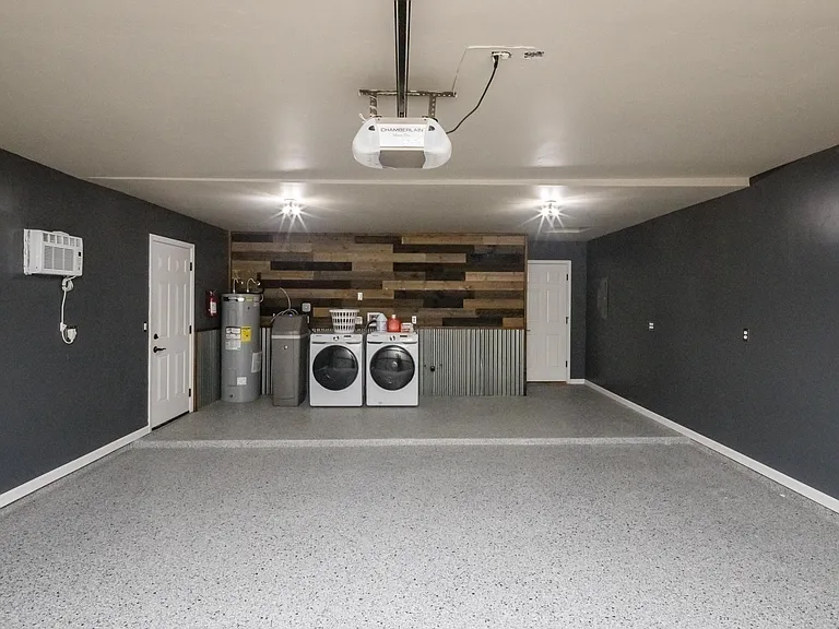 Oversized finished garage with epoxy-style flooring, upgraded lighting, and ample space for vehicles, storage, or recreational equipment.