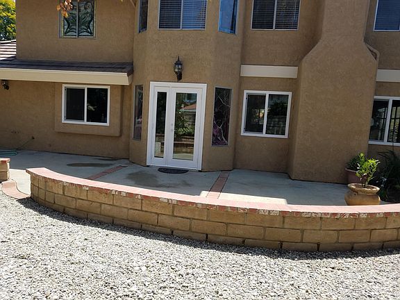 Backyard patio. Large rock area for potted plants, play equipment...