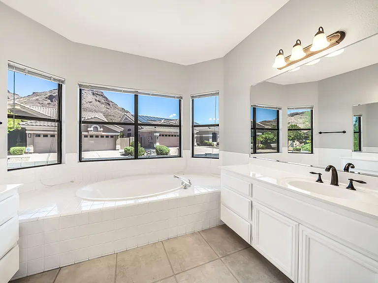 Spacious master bathroom with mountain views and dual sinks.