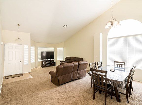 Front entrance and living room with high ceilings and neutral paint. Very clean carpet.