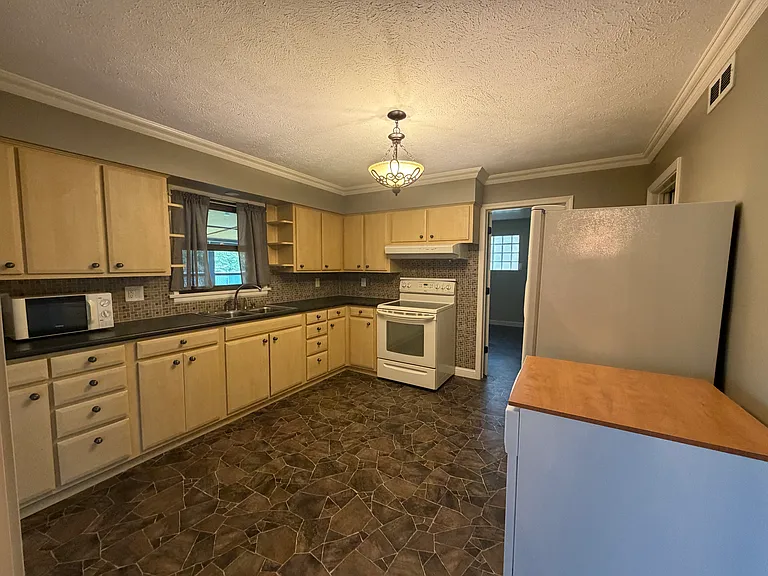Kitchen appliances include oven, range, microwave, refrigerator and portable dishwasher.