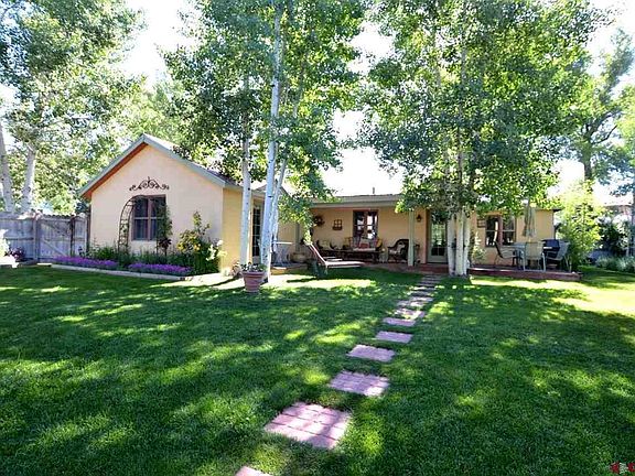 Green grass and colorful flowers in a spacious, private and fenced in back yard to enjoy and relax.