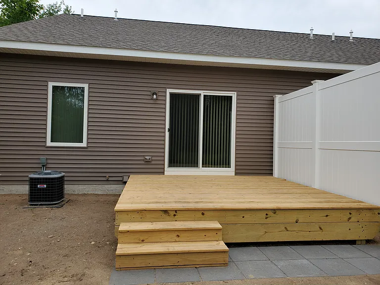 Back deck with grill area facing vacant field.