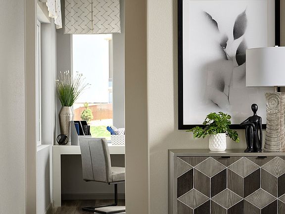 A modern and minimalist living room with a geometric patterned cabinet, a framed abstract artwork, a