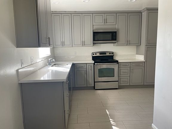 Large kitchen with stainless appliances and designer gray cabinets (including large food pantry).