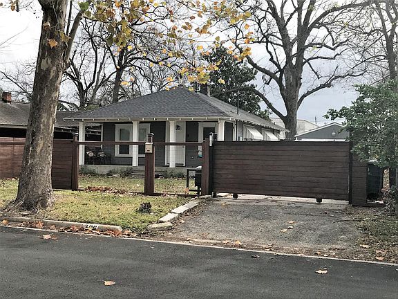 Front of house with fully fenced yard and electric gate.