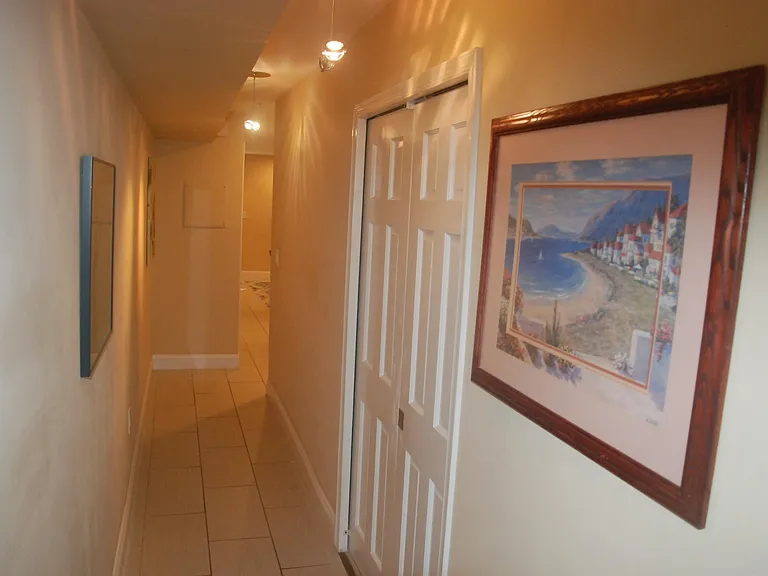 Looking back out the long hallway towards the entrance, with first bedroom doors closed.