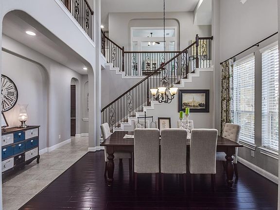 Two story dining room with warm hardwoods.