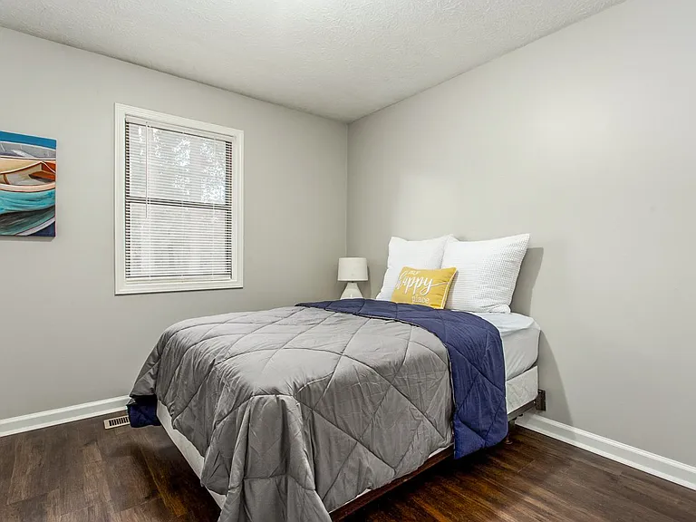 Bedroom with closet, nightstand and lamp.
