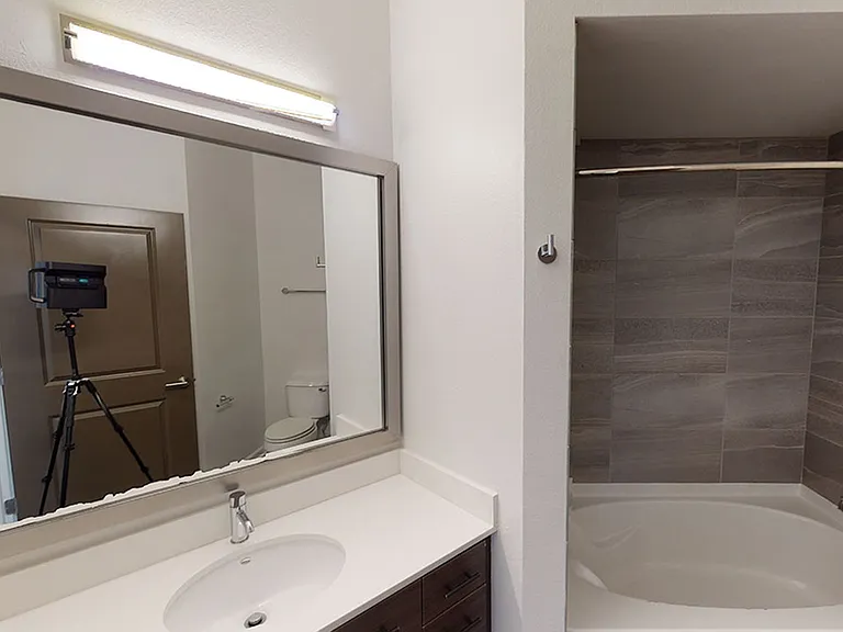 Apartment bathroom with large soaking tub and wood-style flooring.