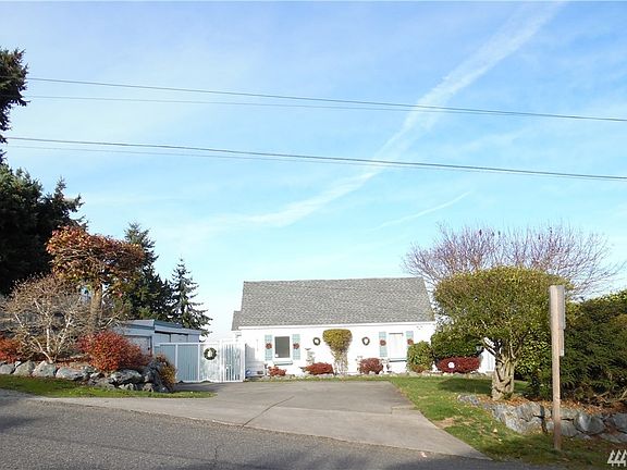 Convenient commute access & tasteful landscaping.  Detached 2 car garage on the left in the photo, shop to the right of the garage.