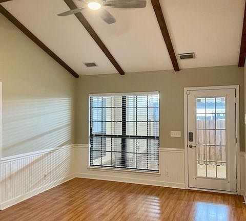 Den with vaulted ceiling and new ceiling fan.