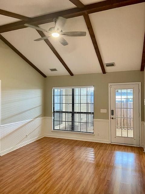 Den with vaulted ceiling and new ceiling fan.