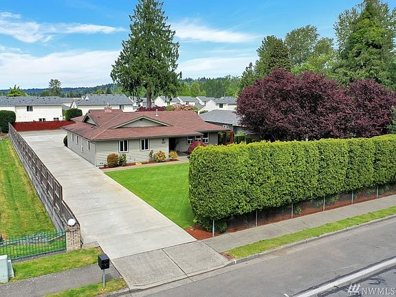The driveway leads to additional parking & detached shop in rear.
