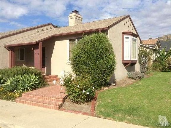 Front door of home with brick entry and covered porch.