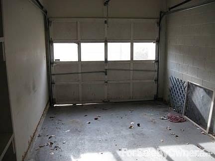 Single vehicle garage : Additional storage space on the back wall; automatic door opener less than a