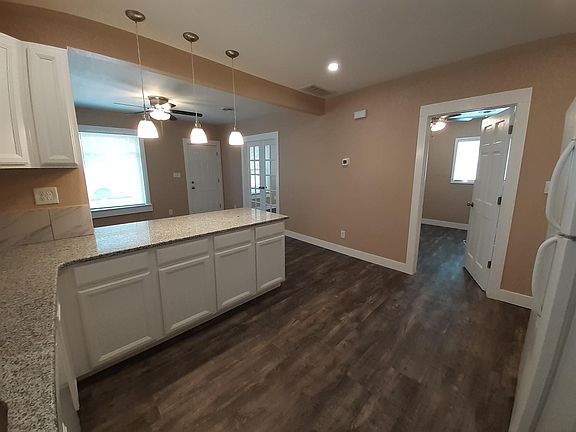 Kitchen with granite countertops, tile backsplash, plentiful cabinet space, dishwasher, and new appliances.