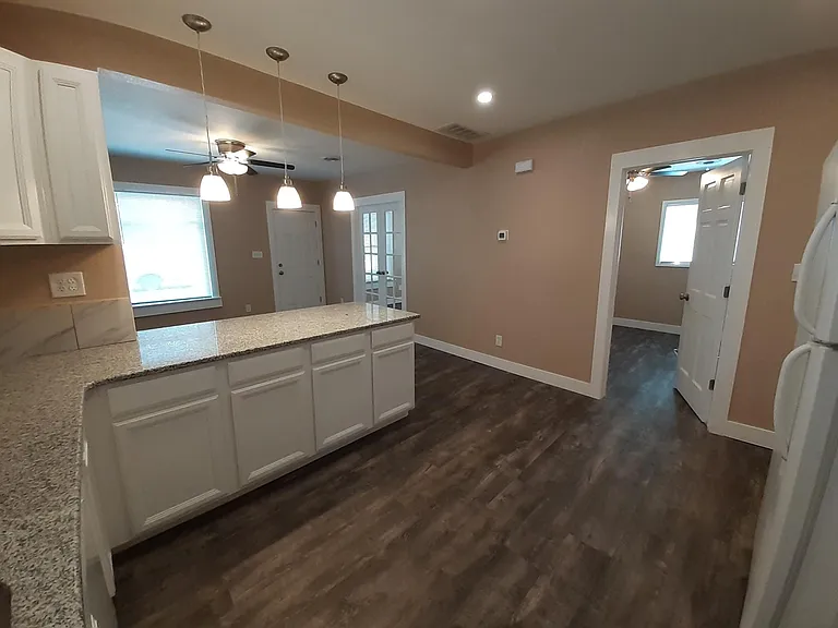 Kitchen with granite countertops, tile backsplash, plentiful cabinet space, dishwasher, and new appliances.
