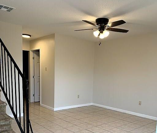 Living room with new ceiling fan and lights. Tile floors downstairs.