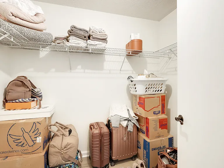 Spacious walk-in primary closet with ample hanging space for a well-organized wardrobe.