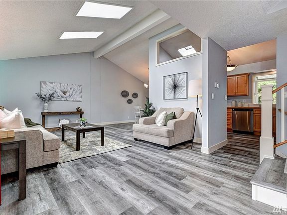 Inviting living room offers tons of light, new luxury vinyl plank flooring and 2 skylights.