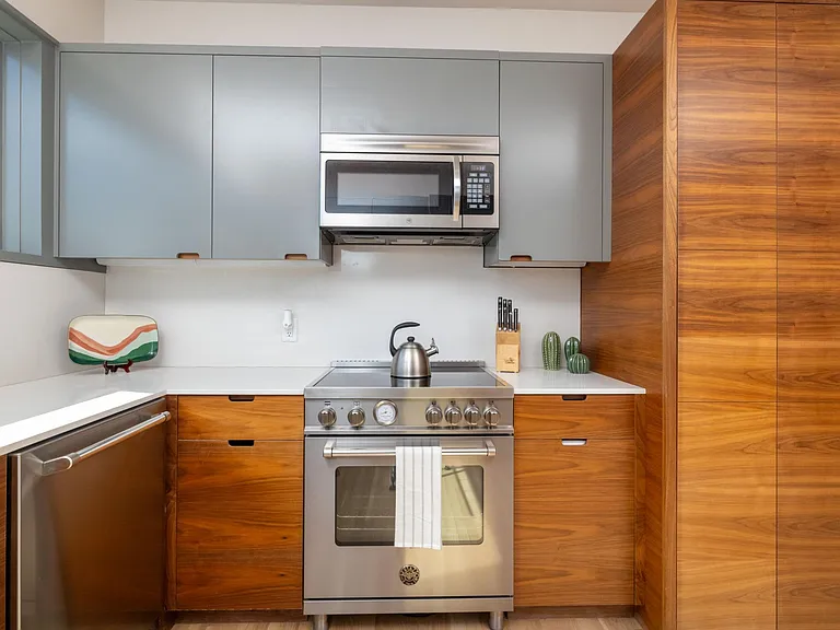 Compact kitchen fully stocked with all essentials and sleek stainless steel appliances_everything you need in a cozy space.