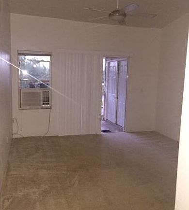 Living Room w/ Vaulted Ceiling, AC, and ceiling fan