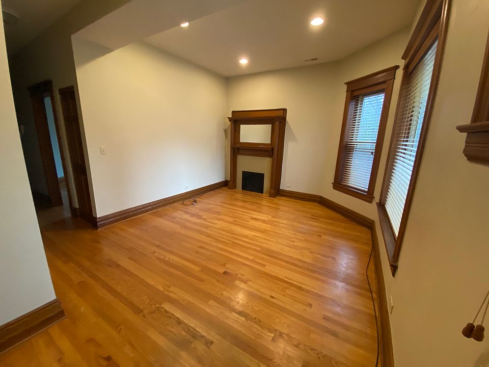 Living room with lots of light and electric fireplace with original mantle.