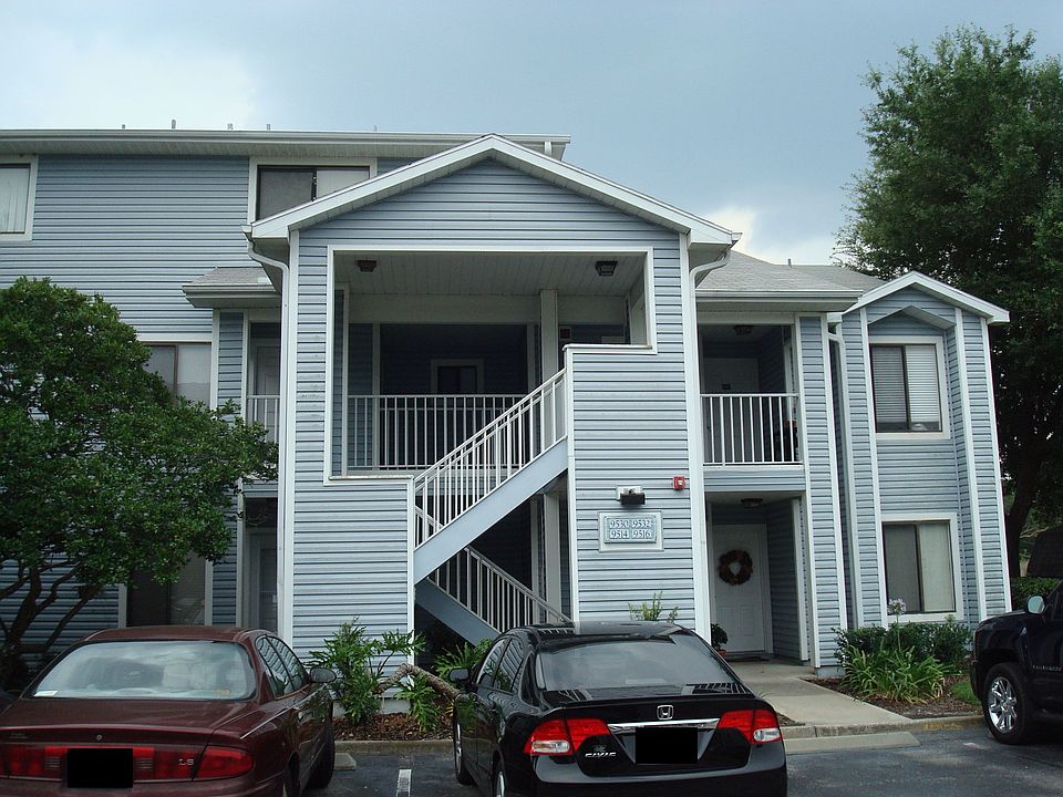 Outside view with parking spot (red car on left)