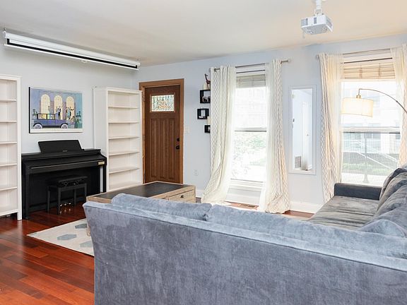 Large couch, piano, coffee table and two bookshelves all comfortably fit into living room.