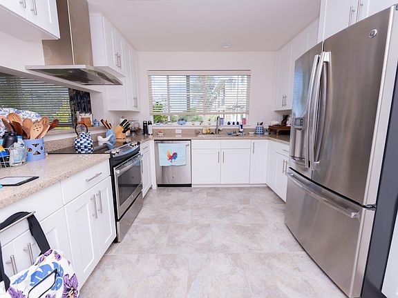 Spacious kitchen with granite tops, stainless appliances, and park views