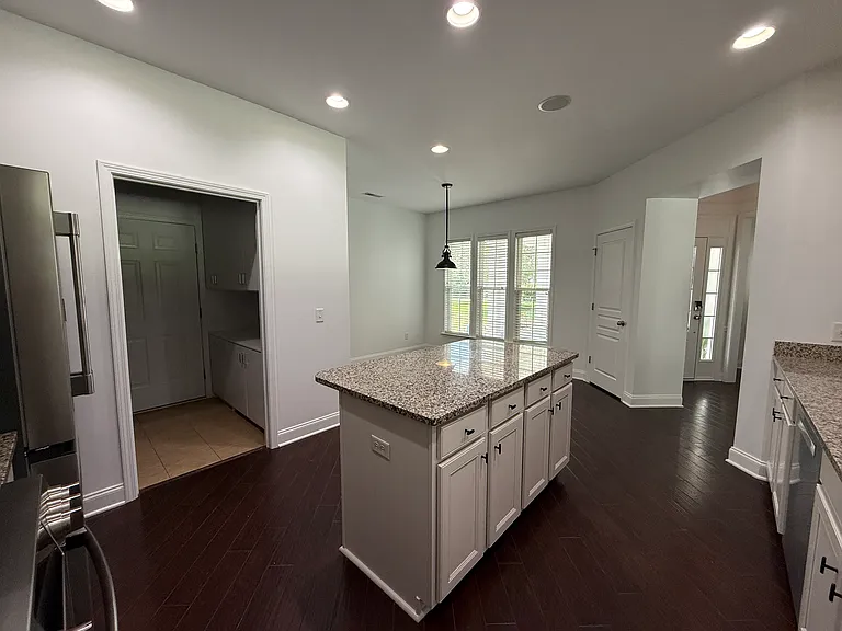 Functional gourmet kitchen island featuring premium granite countertops, extensive integrated cabinet storage, drawer space, and handy built-in electrical outlets."
