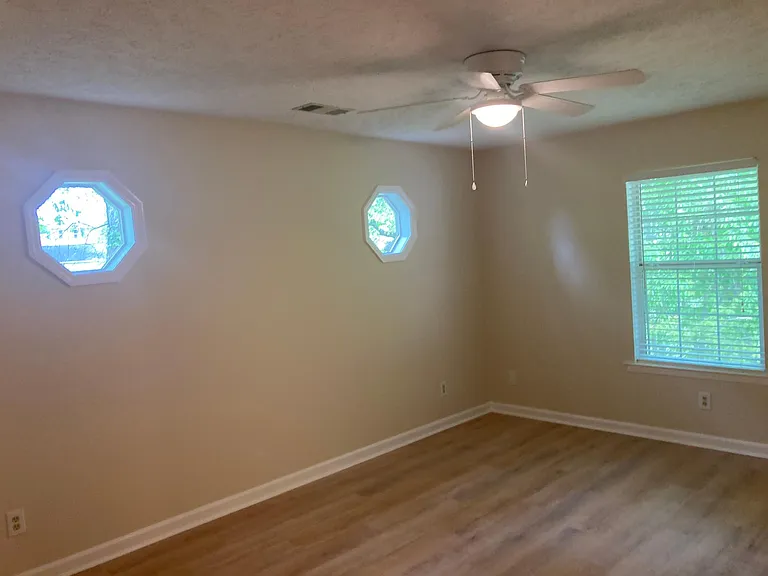 Large master bedroom, private, surrounded by trees includes private bath and walk-in closet.