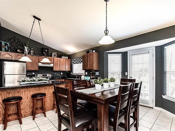 The kitchen island is the center of attention. Newer SS appliances. Bay door opens to backyard and patio