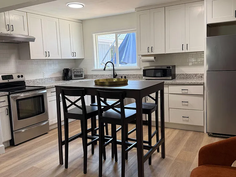 Well-appointed kitchen with ample shaker cabinetry, granite counters, subway tile backsplash, and stainless appliances.