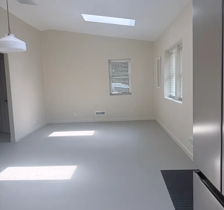 Refrigerator in the foreground, looking East into living room with doorway to hall.