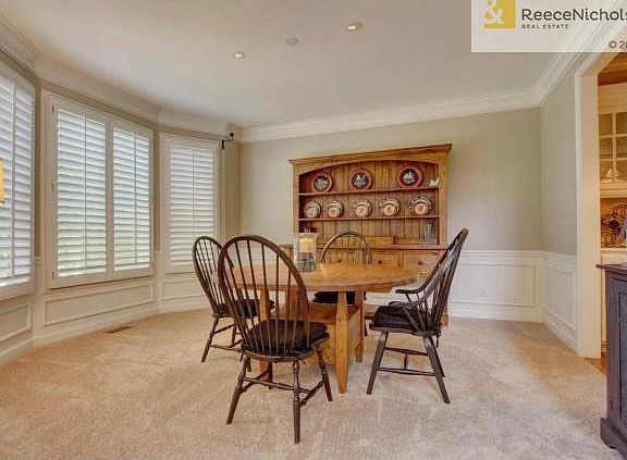 Formal dining room features wainscoting and plantation shutters-