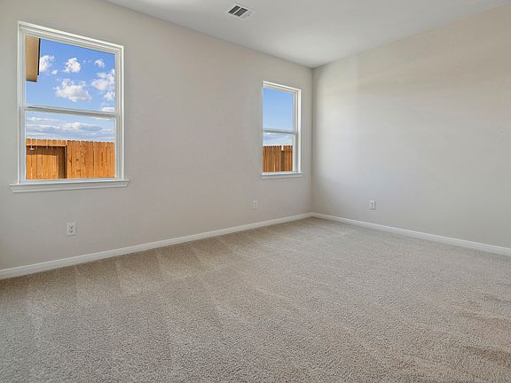 Master bedroom with lush carpet and two windows