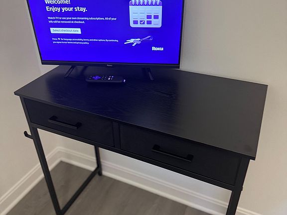 Media nook/ desk with a flat-screen Roku TV on a console table, offering convenient entertainment space for relaxing.