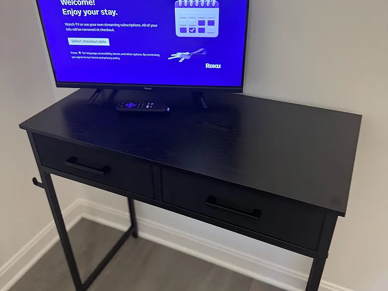 Media nook/ desk with a flat-screen Roku TV on a console table, offering convenient entertainment space for relaxing.
