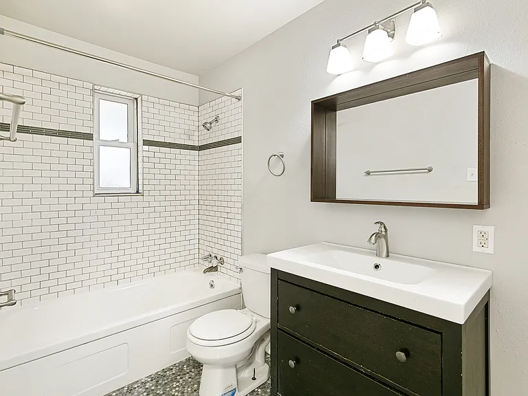 Contemporary bathroom with elegant subway tile walls, modern vanity, and chic lighting.