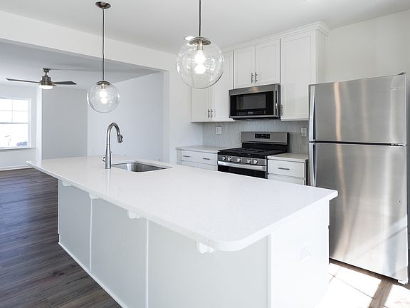 Island kitchen with white cabinets in a DRB Homes York II Garage plan at the Archer s Rock community