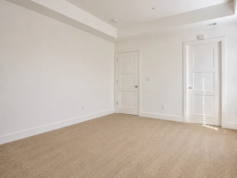 Primary suite _ alternate view showcasing spacious layout and elegant tray ceiling.