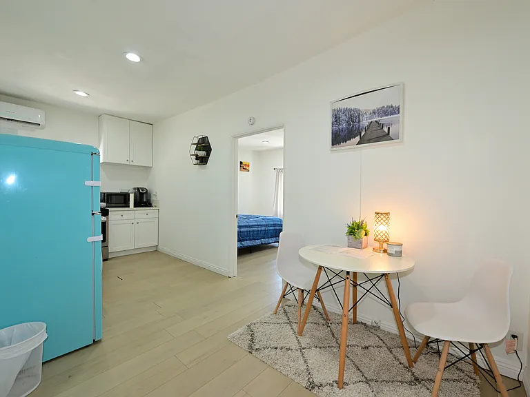Fully furnished living room with upgraded kitchen, appliances, and laundry machines