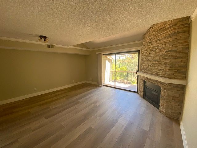 Living Room with a "View & a Balcony"!
Stacked Stone Fireplace with a easy turn on and off remote. Flooring is a rich earth tone Vinyl plank style. crown molding and updated overhead lighting.