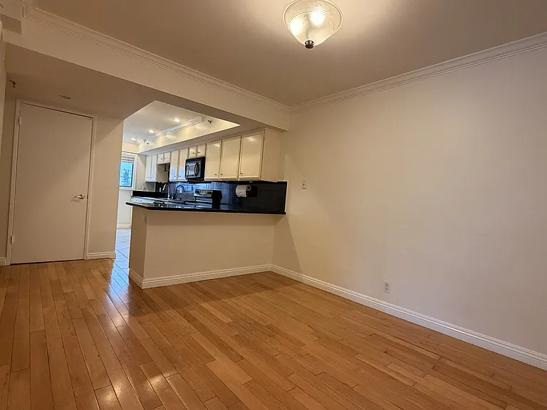 Dining area with open connection to the kitchen and hardwood flooring.