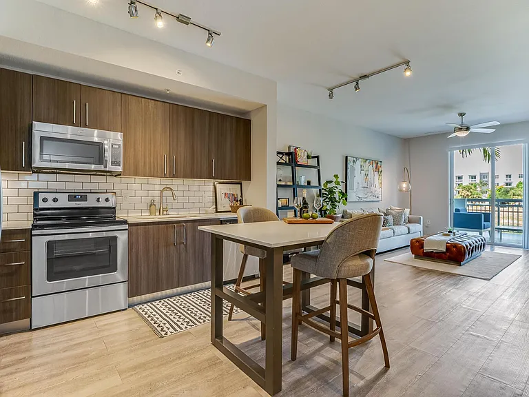 Kitchen and Living Room View with Island and Private Balcony Access